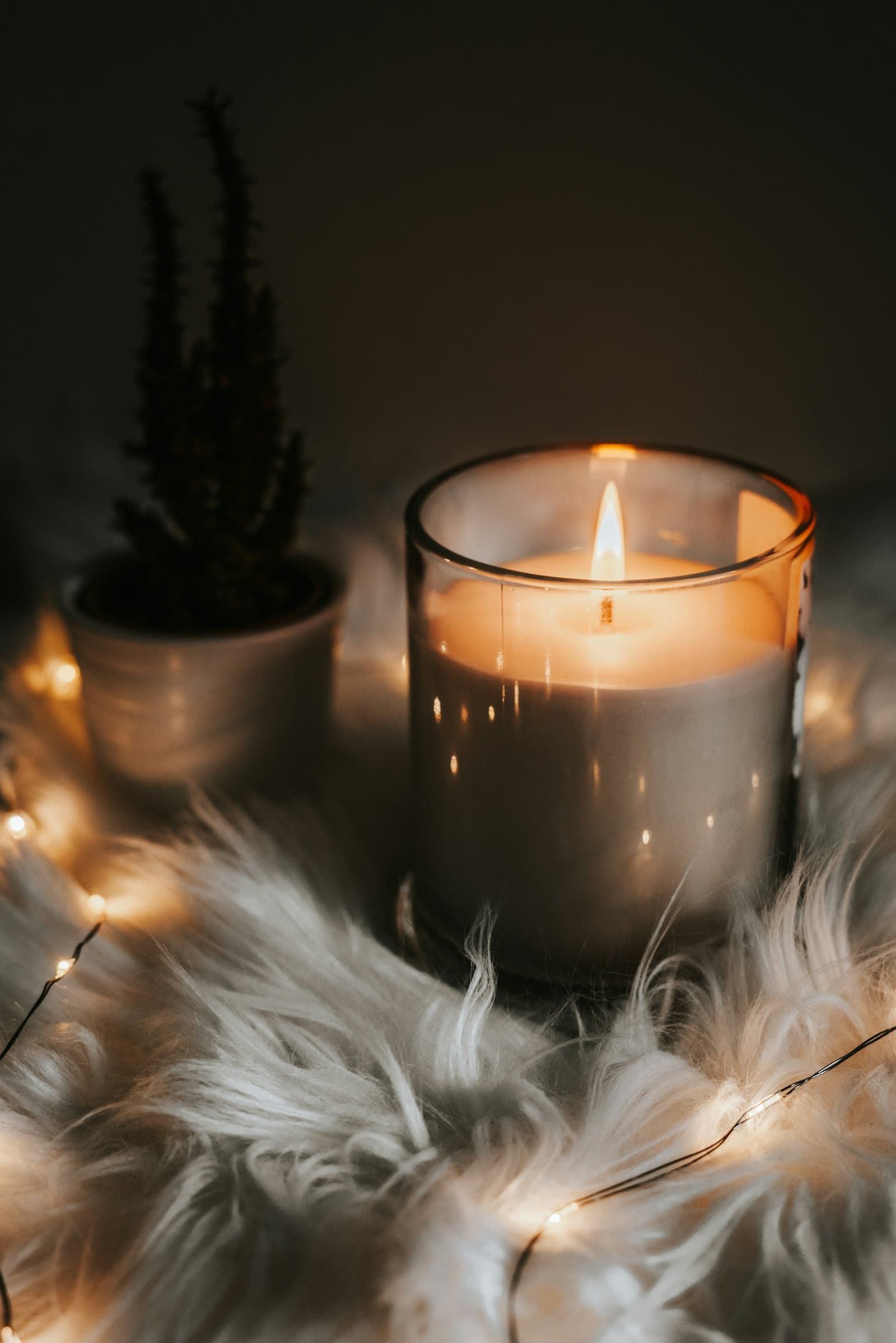 A candle glowing softly among scattered points of light in the dark.
